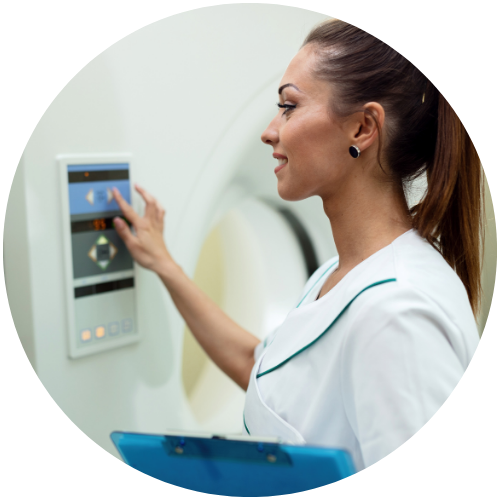 A person in a medical uniform operates an MRI machine, using a touchscreen interface, holding a clipboard.